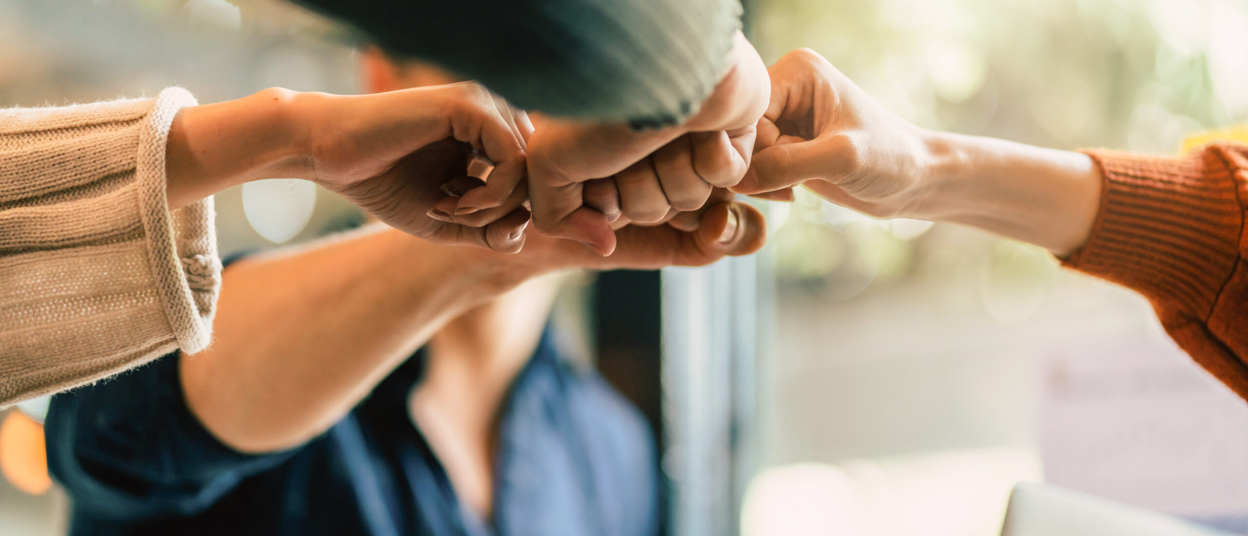 Close-up of a diverse team doing a group fist bump, symbolizing trust, unity, and partnership—representing the importance of choosing the right dental billing company.